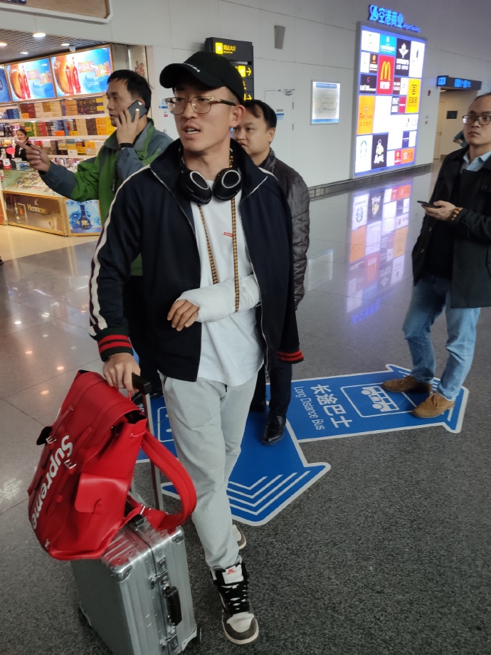 机场继续宣!华夏受伤国脚抵达广西 手上还缠着绷带