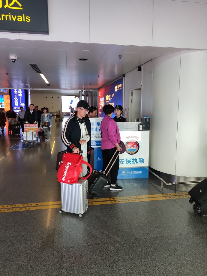 机场继续宣!华夏受伤国脚抵达广西 手上还缠着绷带